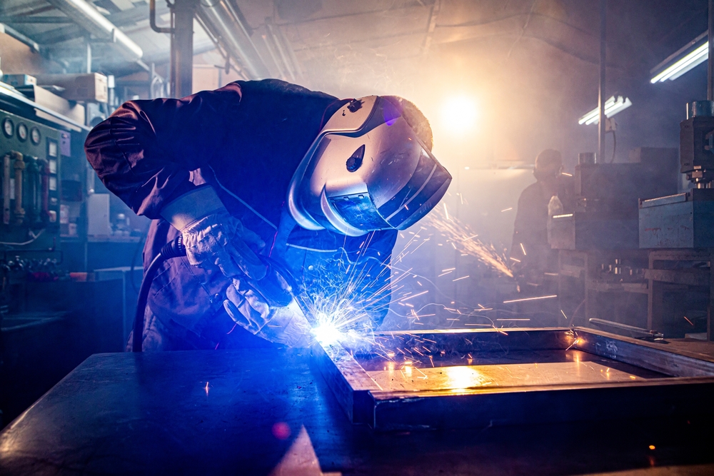 Worker,with,protective,mask,welding,metal,in,workshop