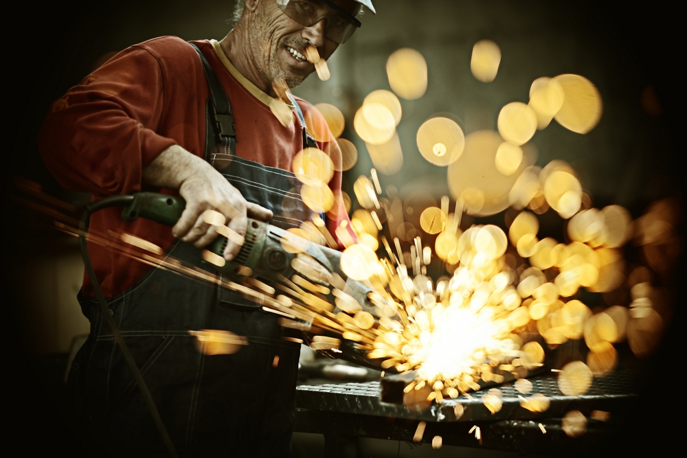 Industrial,worker,cutting,and,welding,metal,with,many,sharp,sparks